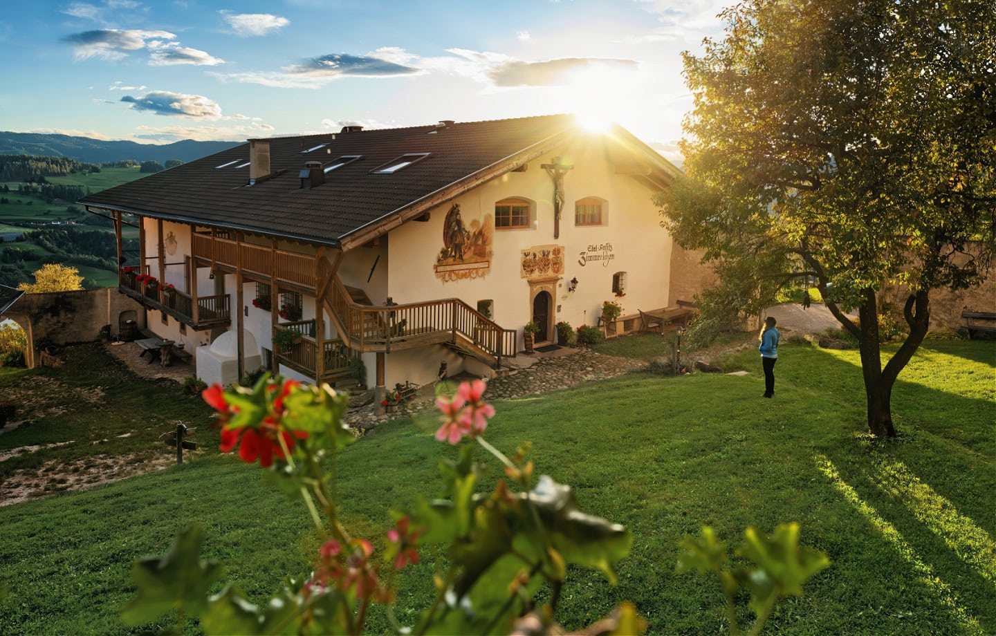 A woman standing in front of Edelansitz Zimmerlehen during an amazing sunset in autumn.
