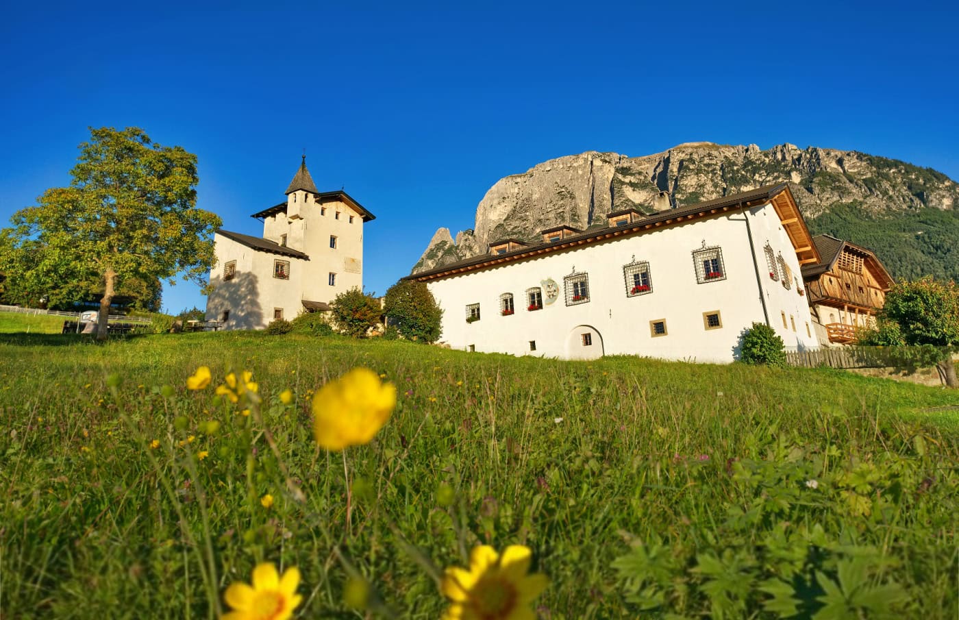 Edelansitz Zimmerlehen at the foot of Mt. Schlern on a sunny afternoon in autumn.