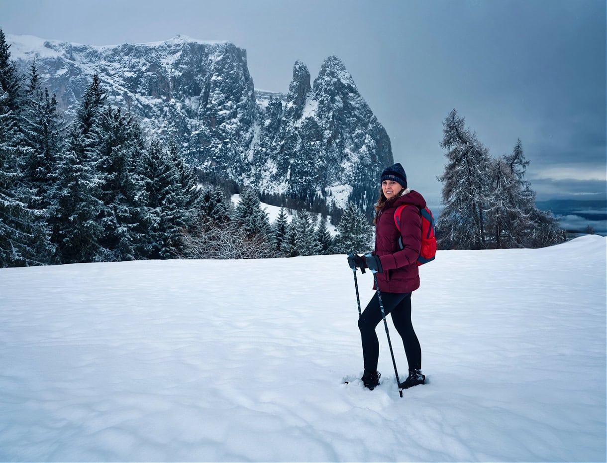 A girl hking Alpe di Siusi / Seiser Alm on a coudly day in the Dolomites winter season. 