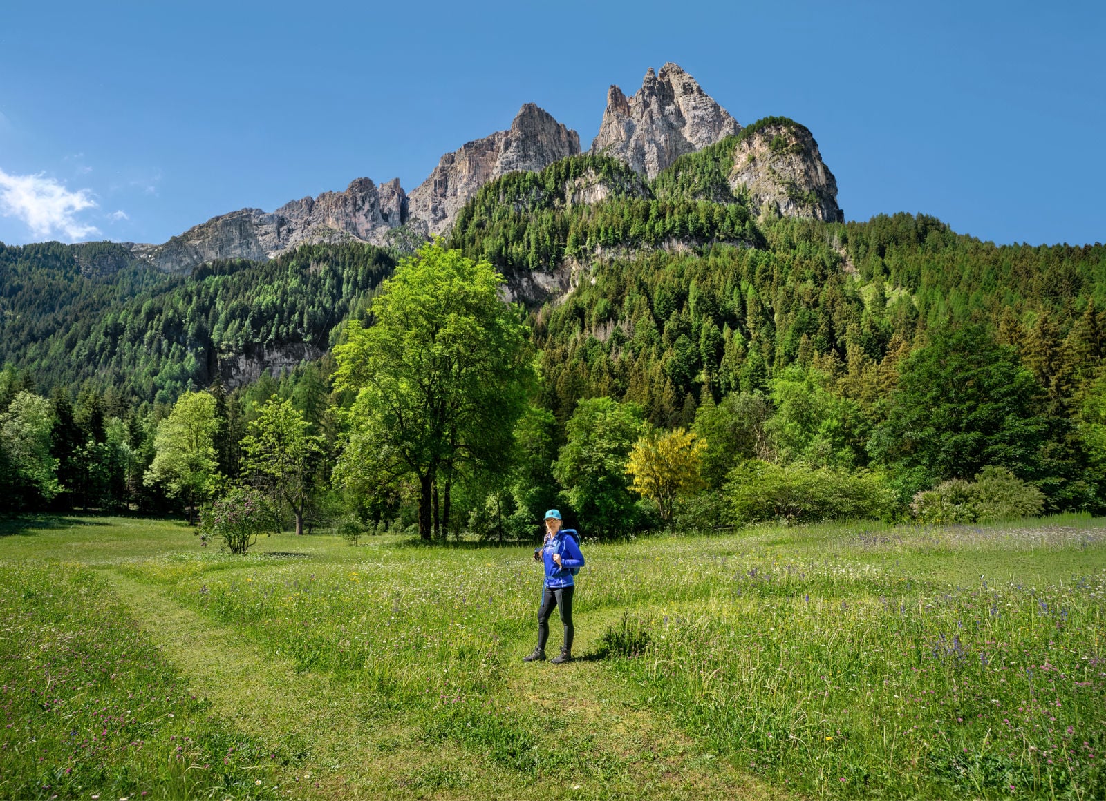 Hike the Geologensteig: 240 Million Years of Fire, Sea & Stone in the Dolomites 2 Kate standing beneath Schlern at the trailhead to the Geologensteig in the Dolomites.