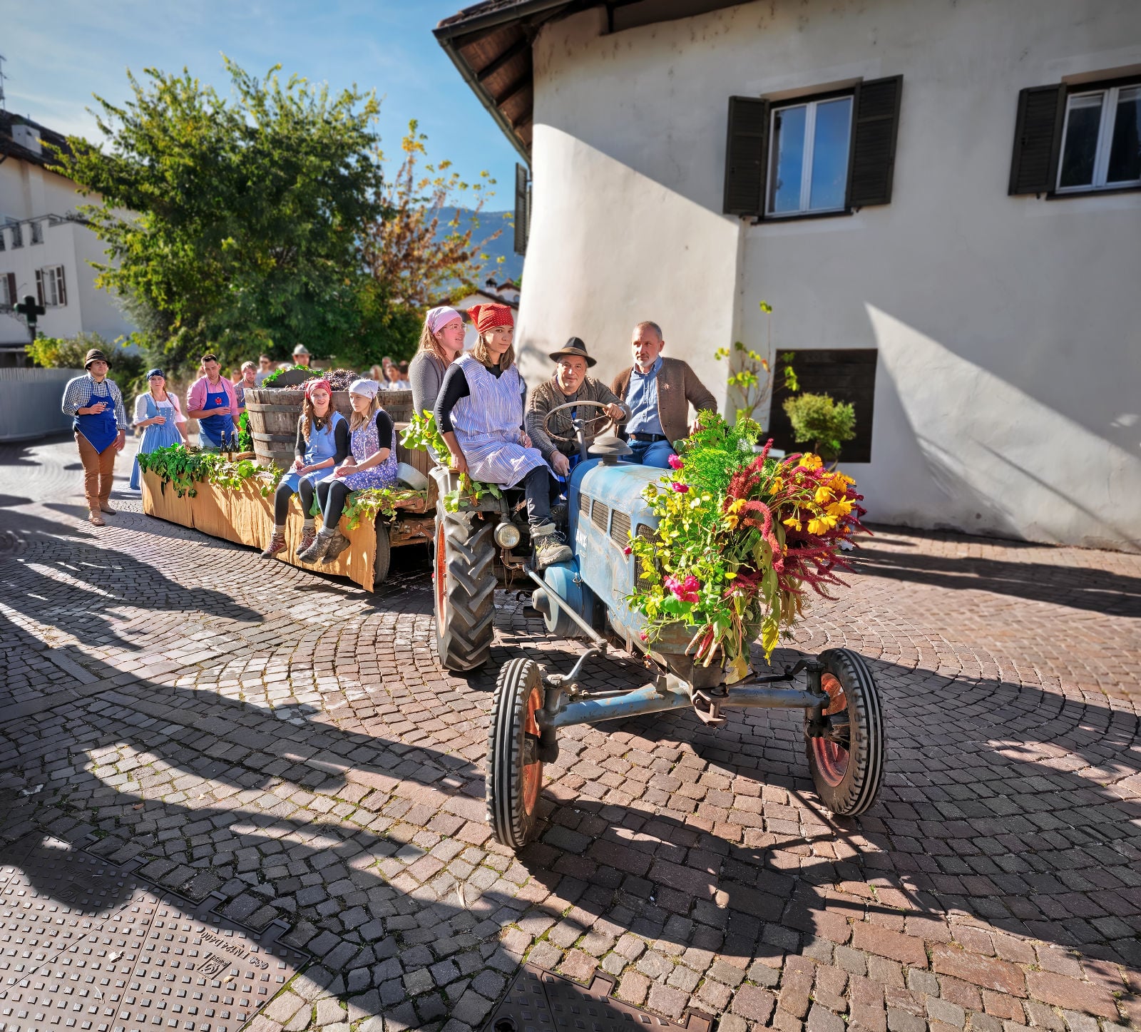 From Vine to Village: Raise a Glass at South Tyrol's Last Load of Grapes Festival 6 A tractor decorated with flowers pulling the grapes at the Last Load of Grapes Festival in Girlan, South Tyrol.