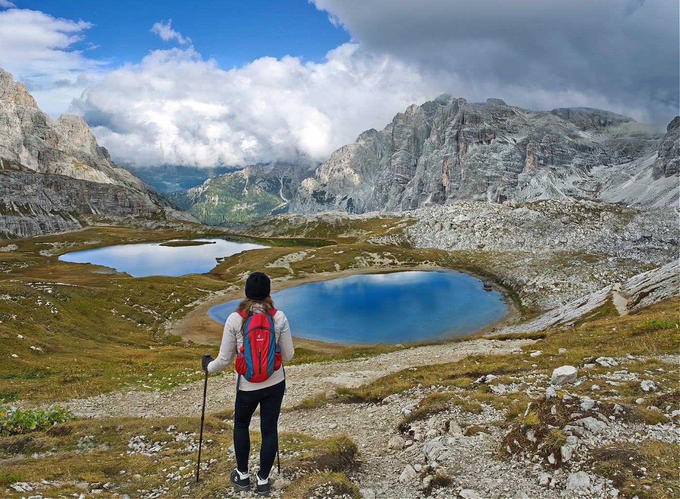 Beyond the Peaks: 12 Must-See Lakes in South Tyrol and the Dolomites 19 A girl hiker standing in front of two Dolomites lakes on a day in October.