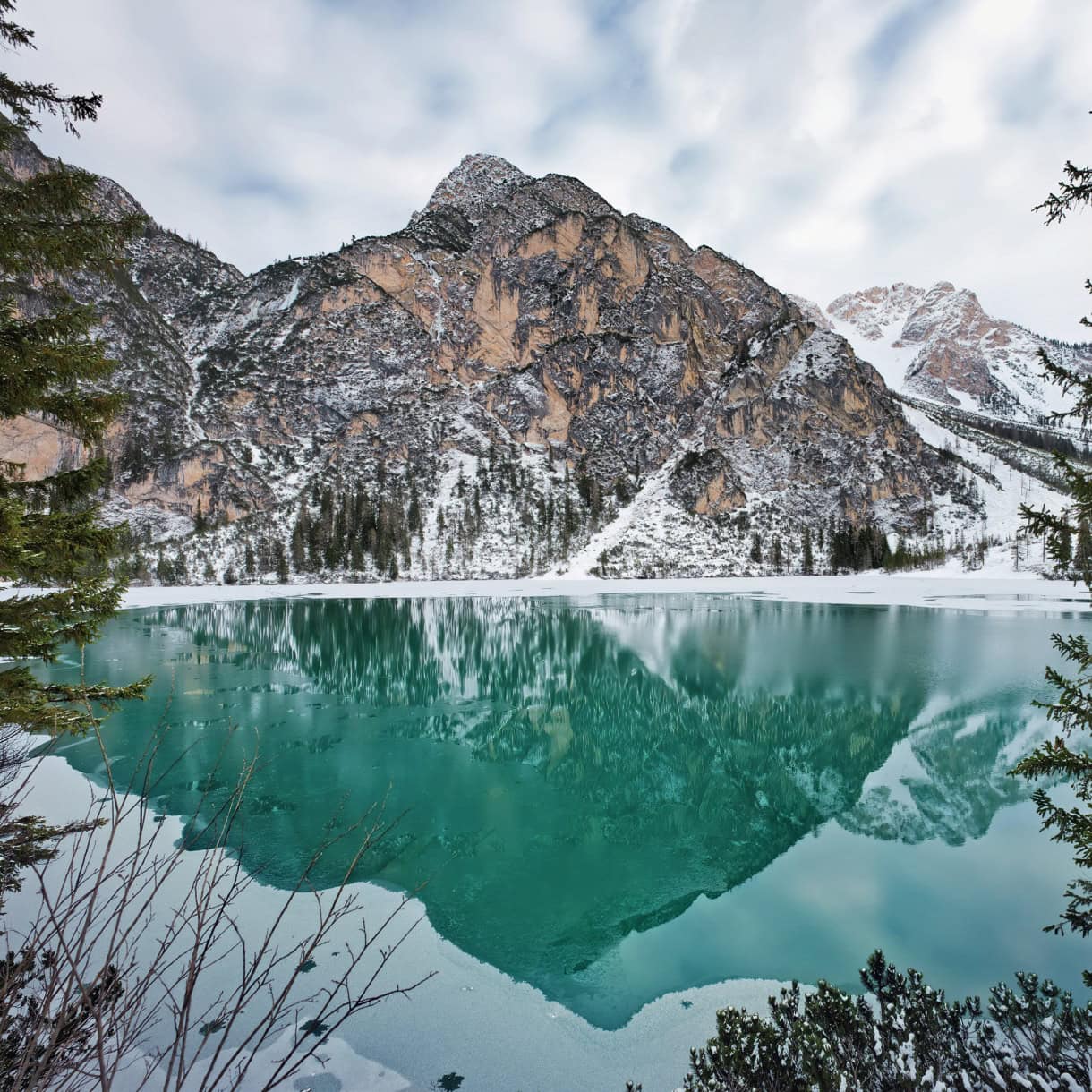 Open ice on Lago di Braies with snow on the Dolomites.