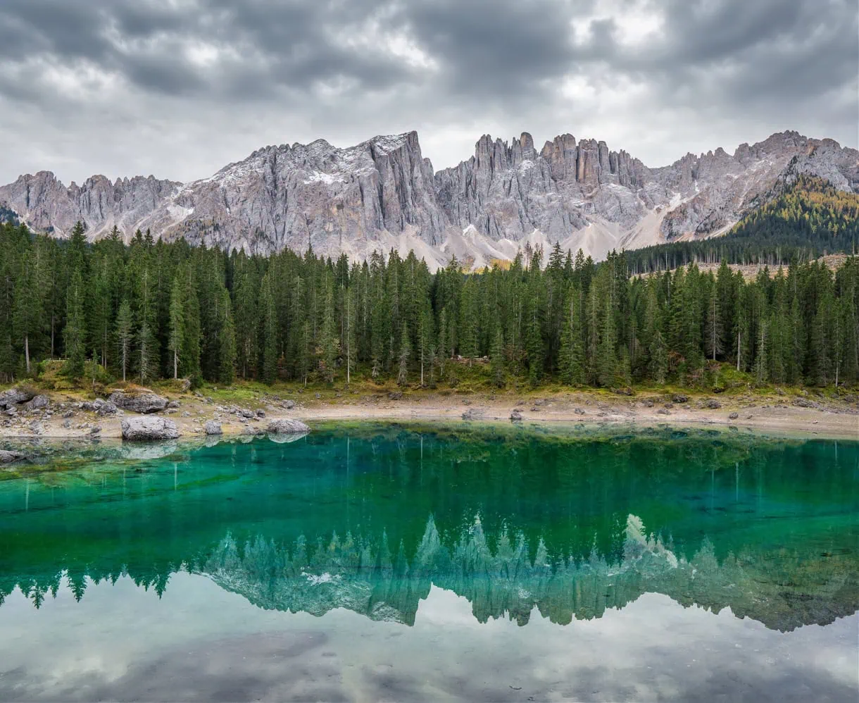 Beyond the Peaks: 12 Must-See Lakes in South Tyrol and the Dolomites 5 Lago di Carezza, also known as Karersee, relfecting the Latemar massif on a cloudy day in autumn in the Dolomites of South Tyrol.