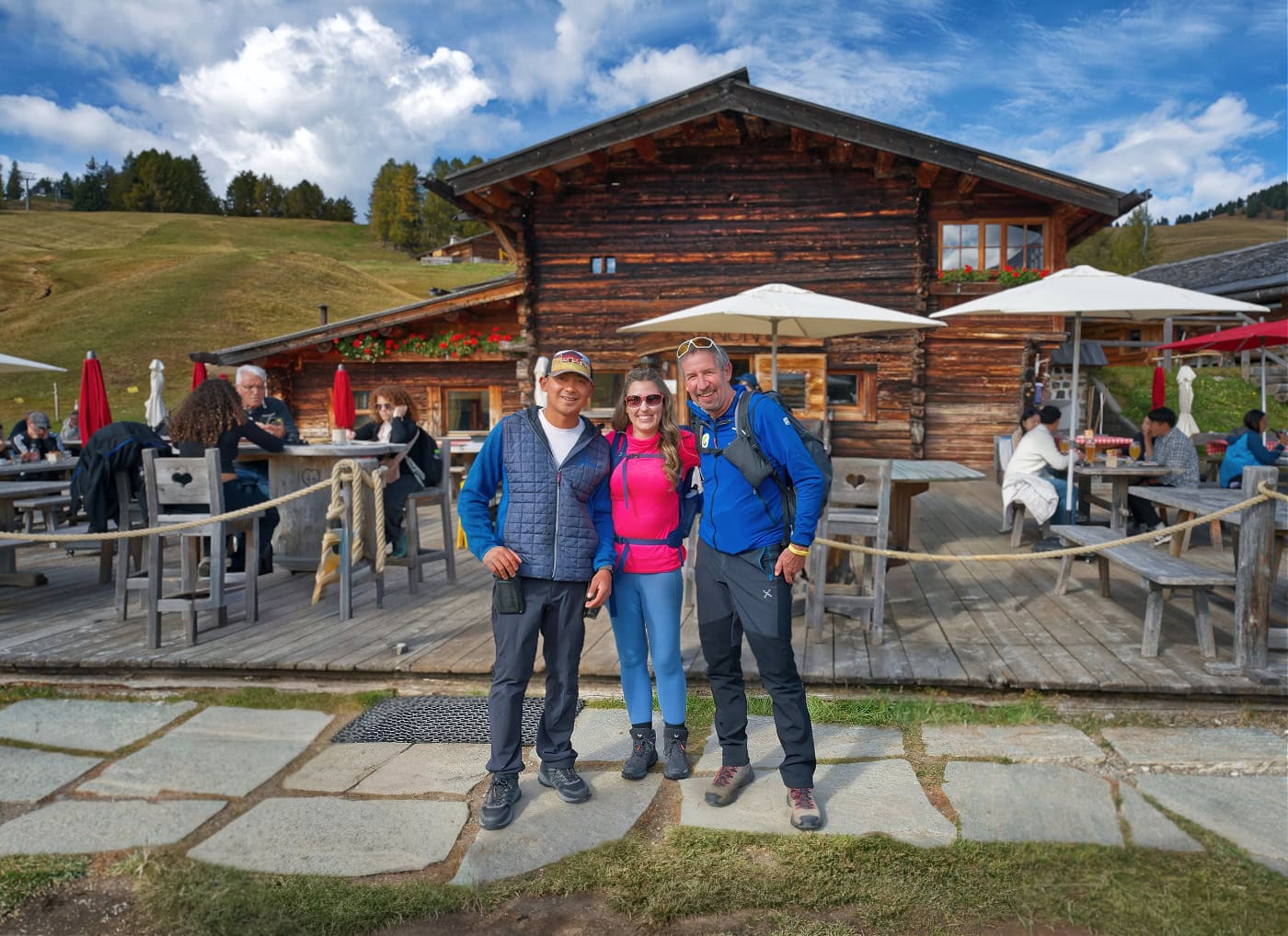 Aquila Dolomites Residence: Ortisei Below, the Dolomites Beyond, and You in Between 13 Kate and Theo standing in front of Malga Sanon with the manager of the hut.