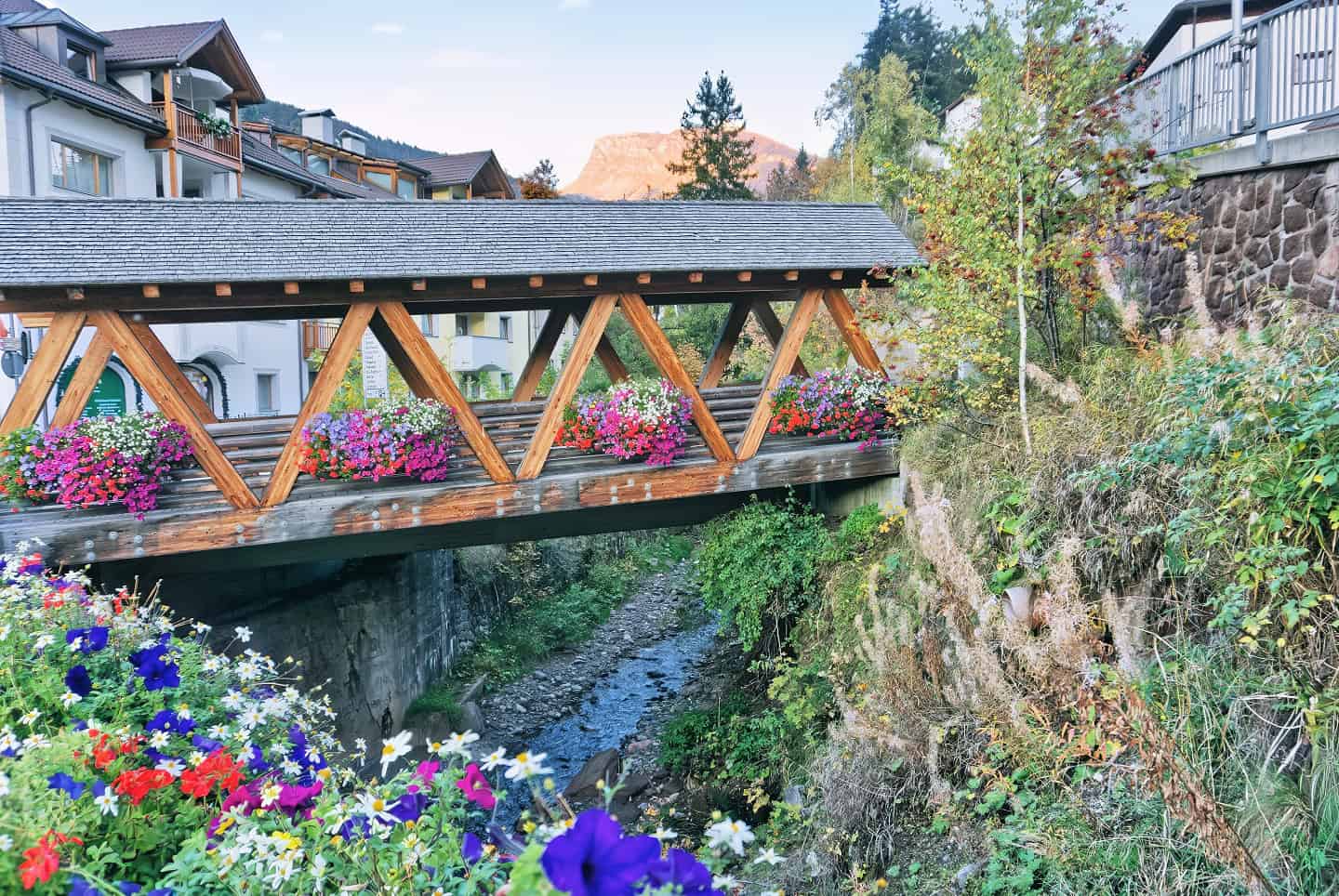 Hiking Seceda: Your 2026 Guide to the Dolomites' Most Iconic Peaks 35 A flower filled footbridge in Ortisei.
