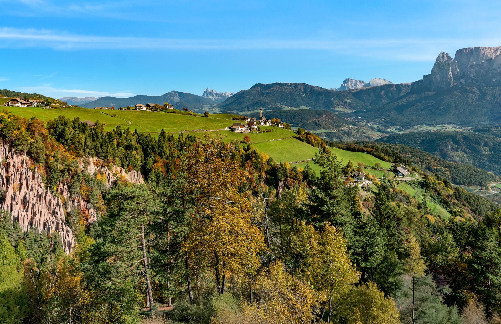 Earth Pyramids of Renon: How to Visit South Tyrol's Strangest Natural Wonder 6 The Earth Pyramids of Renon from the Lengmoos viewing platform, with St. Nicholas Church, Seceda, Sassolungo and Schlern in the distance.