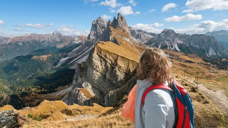 A female hiker standing at the famous Seceda viewpoint in Val Gardena.