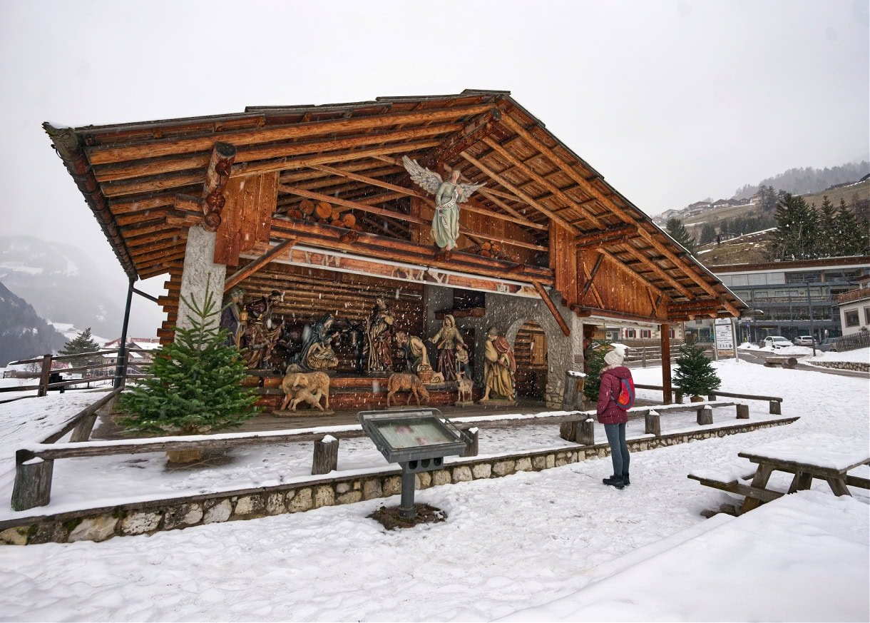 A woman admiring the the world’s largest hand-carved nativity scene in Santa Cristina in the Dolomites in winter. 